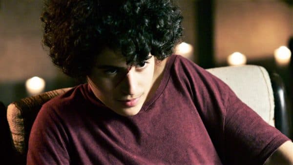 ילד יושב על כורסא ומביט במבט מכושף